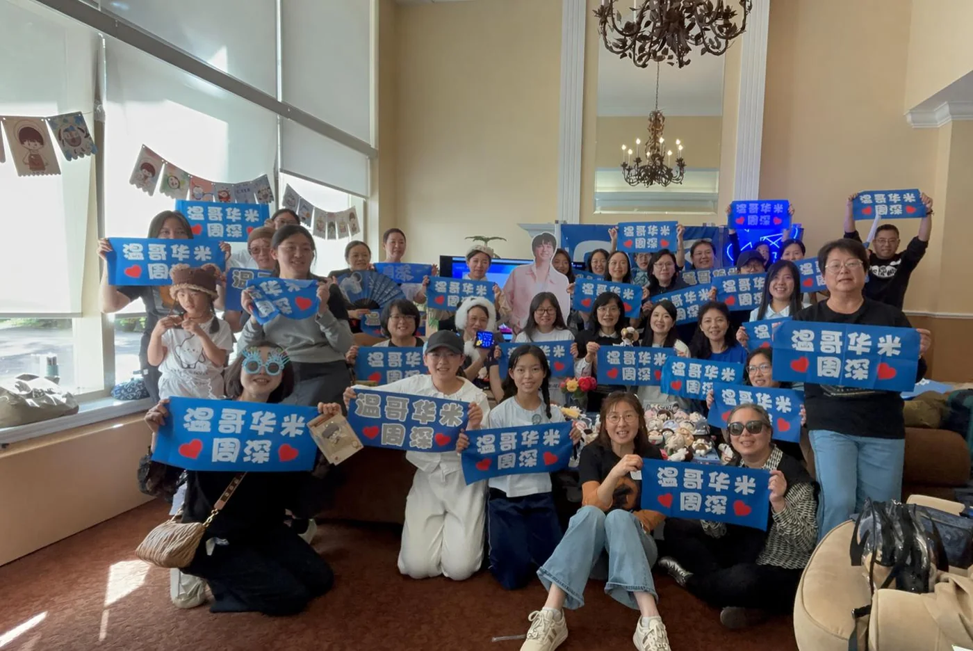A group photo of the community gathered together indoors.