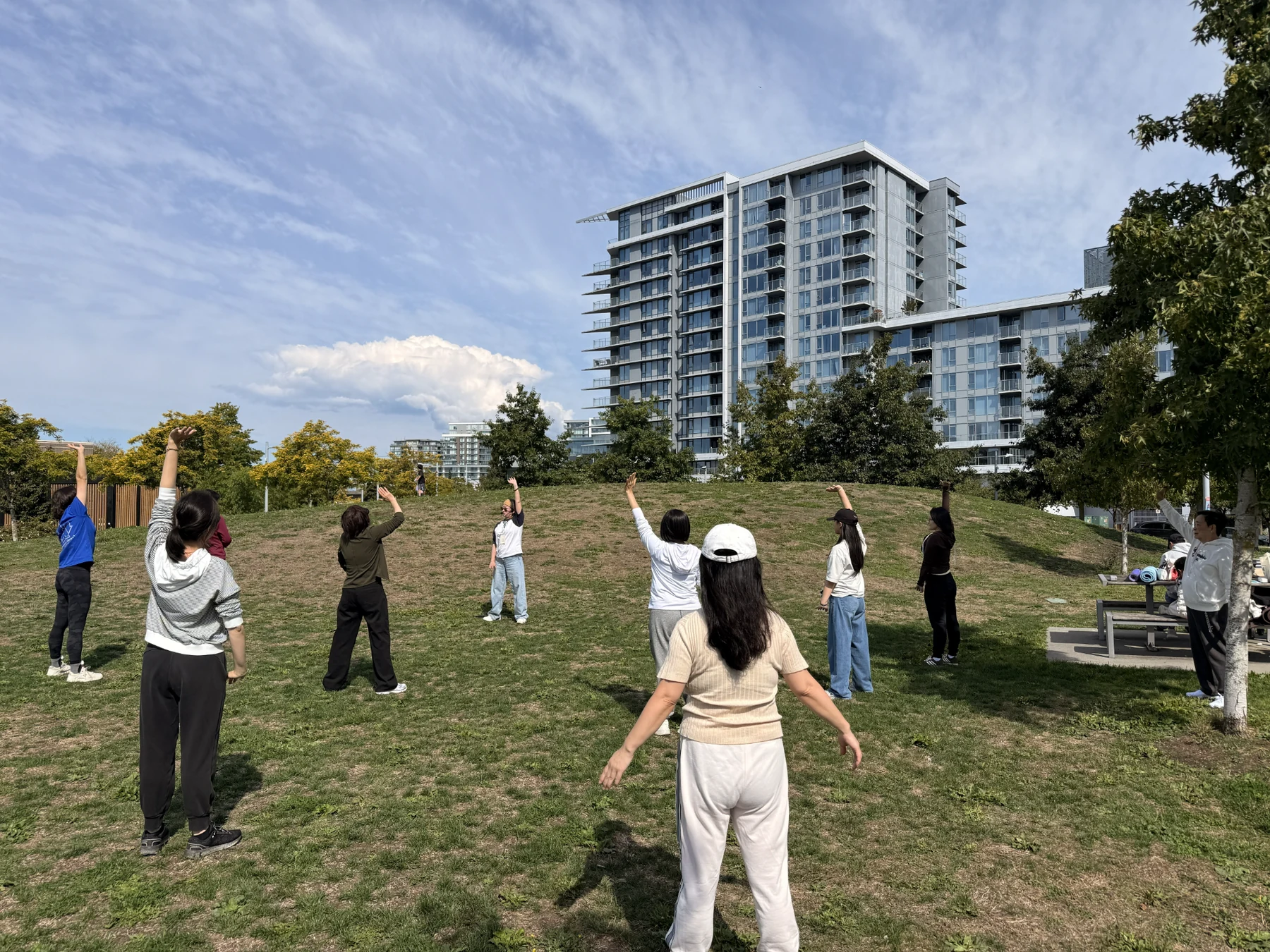 Neighbours practicing Baduanjin together on the grass at Aberdeen Neighbourhood Park in Richmond.
