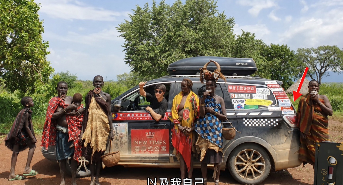 A full screenshot of the travelling car covered with stickers, with a red arrow pointing to Janet’s Zhou Shen sticker.