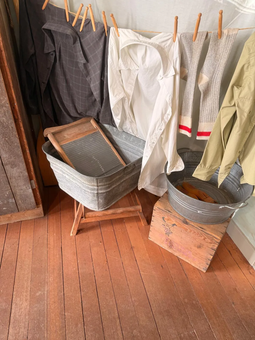 Historic clothing, wash tubs, and a washboard displayed inside a Steveston home.