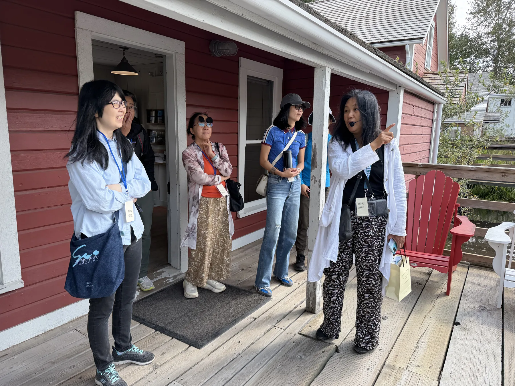 Community members listening to a guide outside a historic red building in Steveston.