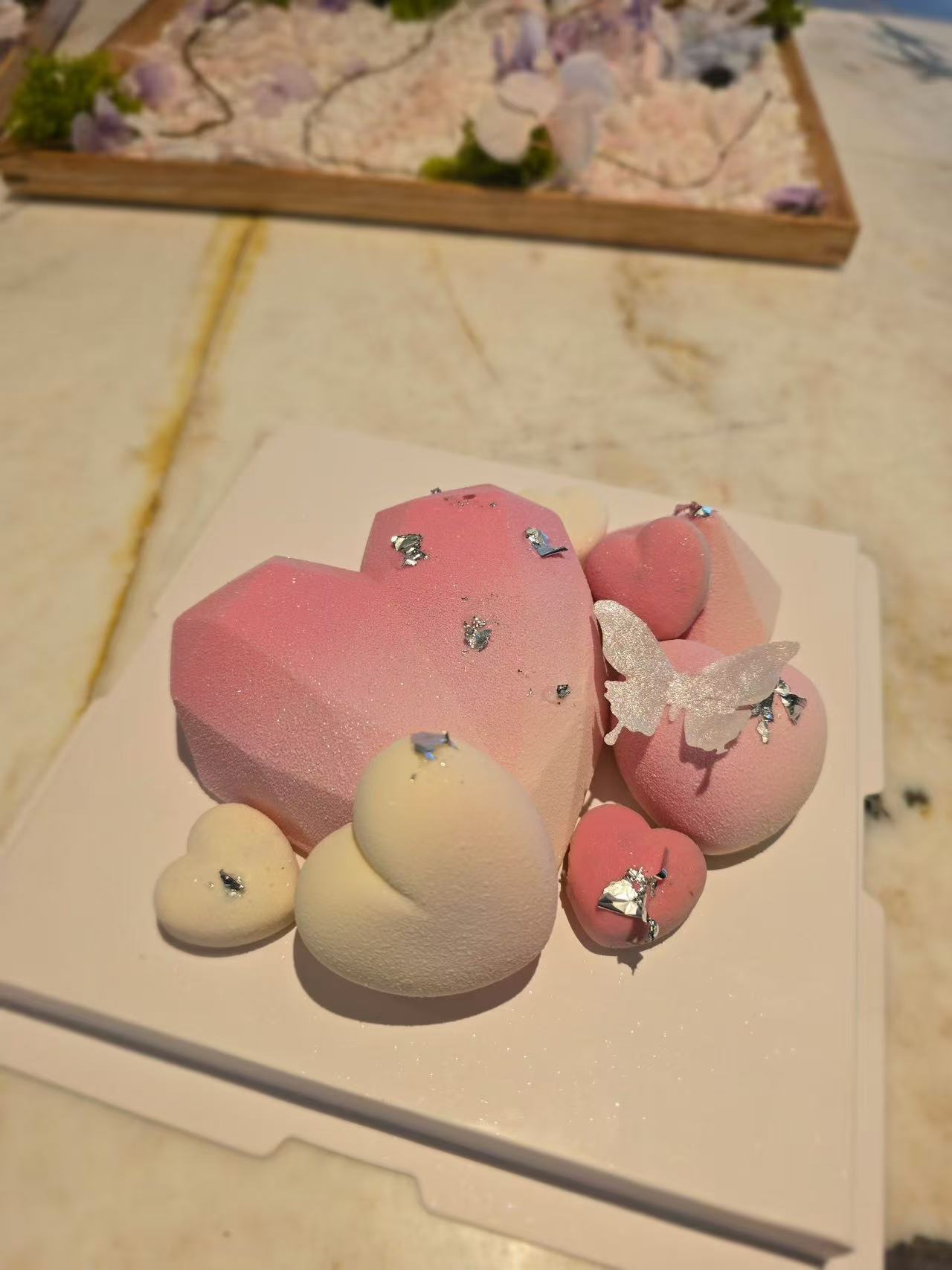 A pink heart-shaped dessert decorated with small silver details.