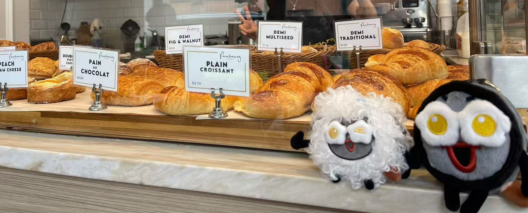 Cafe pastries displayed beside two Shengmi plush dolls.