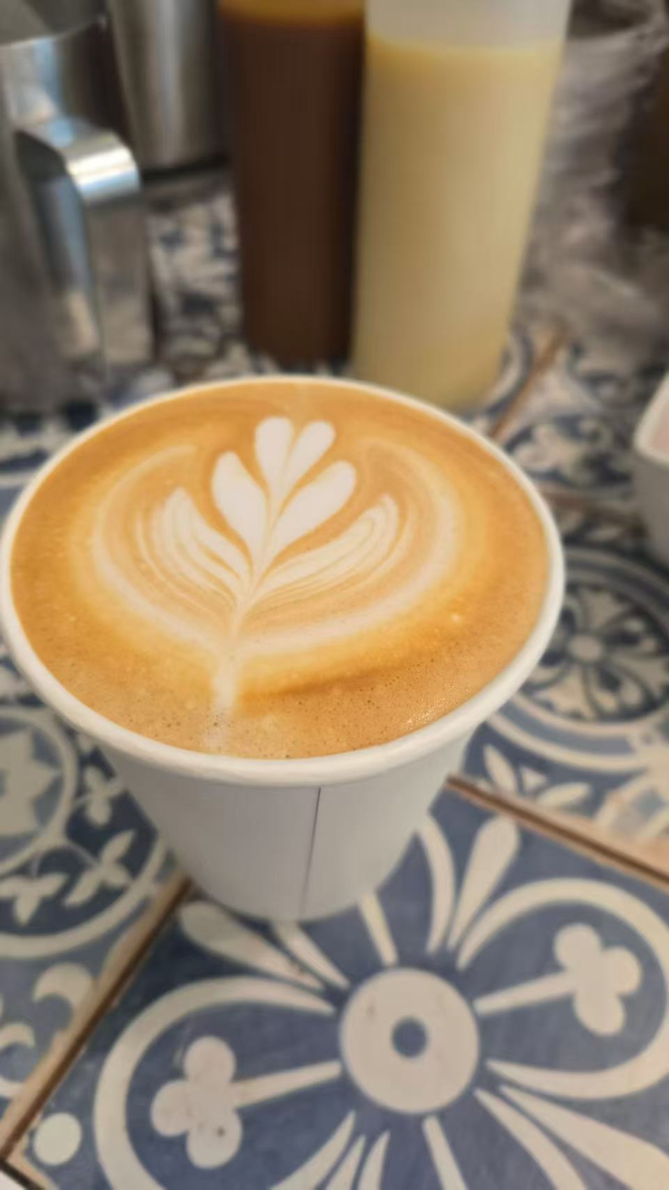 A cup of latte with leaf-shaped latte art.